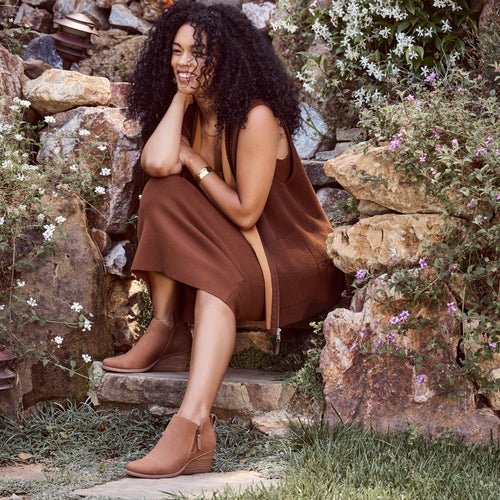 Goldie brown leather wedge ankle boot on model styled in a transitional fall dress