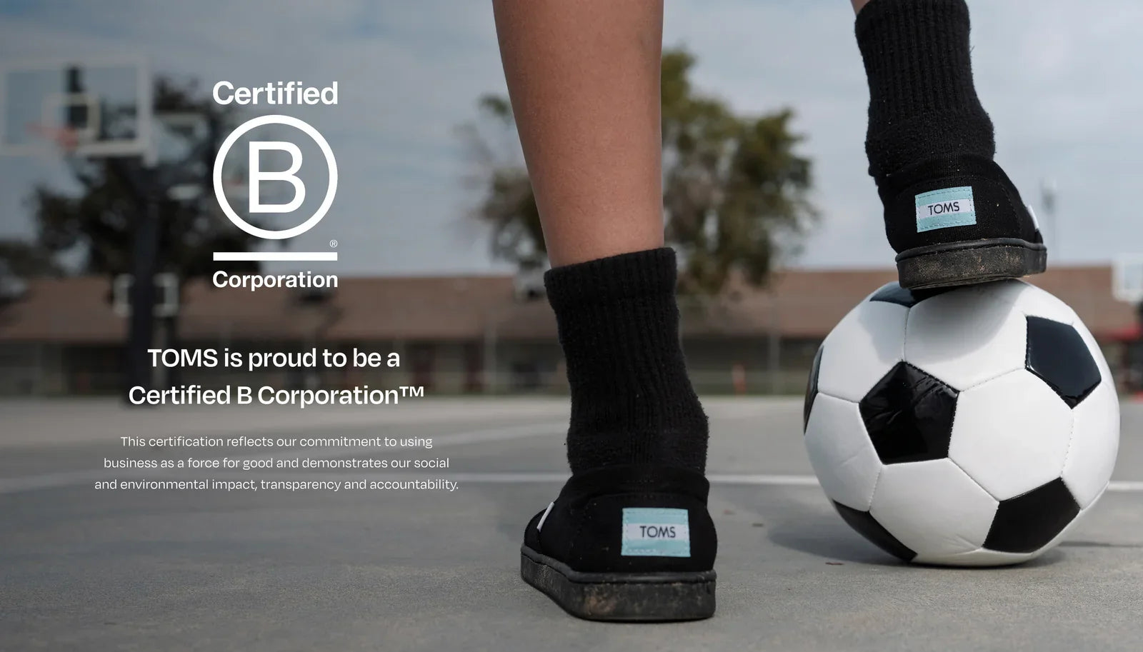 Bcorp logo. TOMS is proud to be a  Certified B Corporation™. This certification reflects our commitment to using business as a force for good and demonstrates our social and environmental impact, transparency and accountability. Child resting foot on soccer ball.