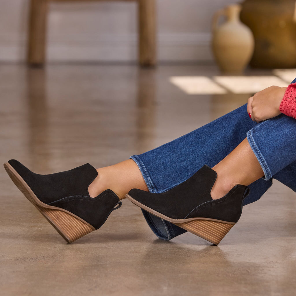 Model wearing black suede Gwen wedge bootie