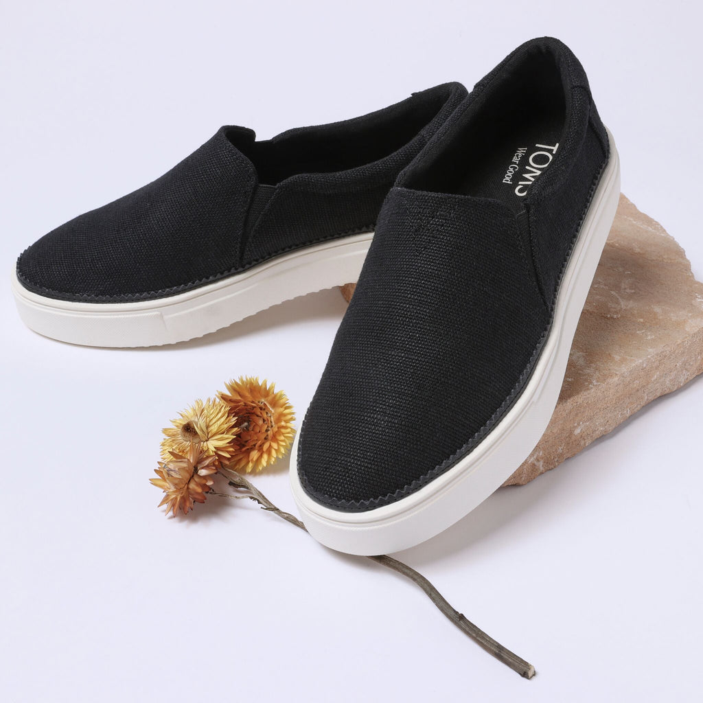 Laydown detail image of the black canvas Emily slip on sneaker