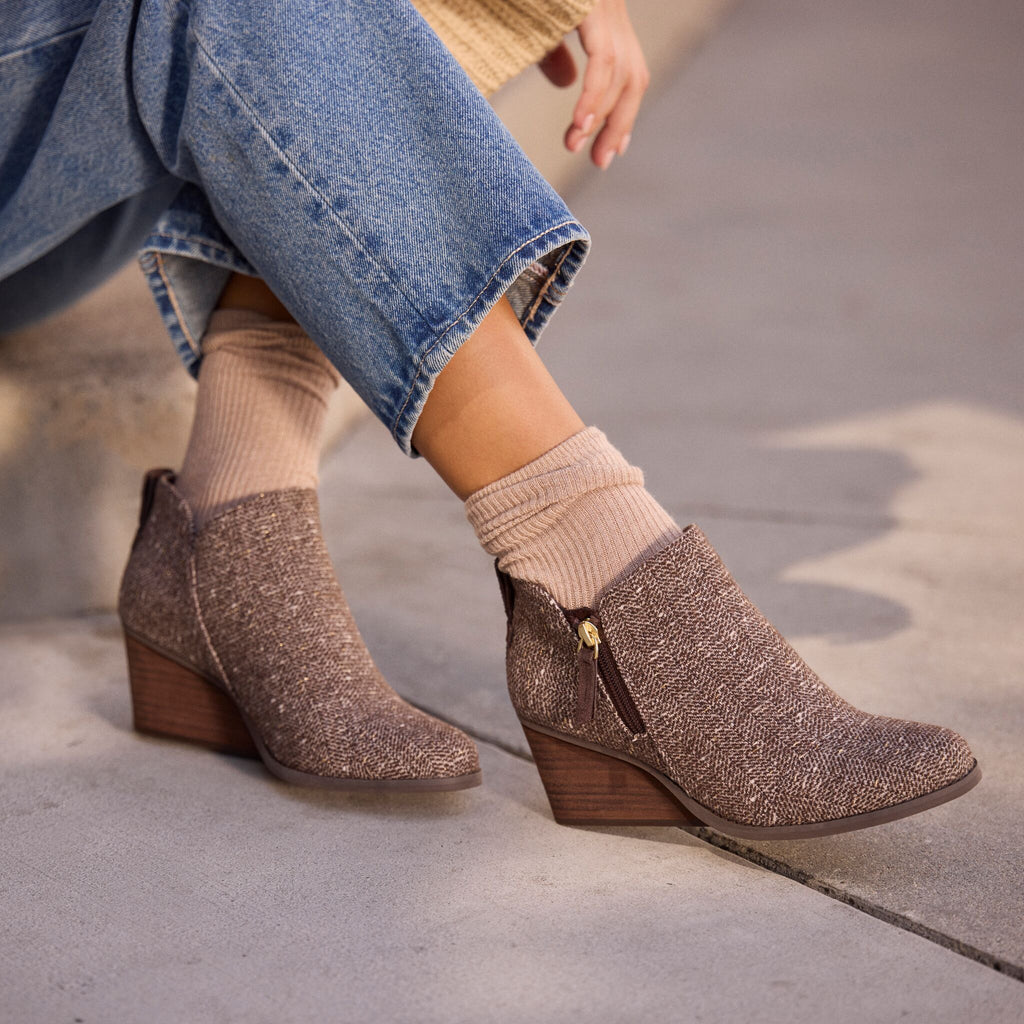 On model image of the Womens Goldie Wedge Ankle Bootie Metallic Twill Chocolate Brown