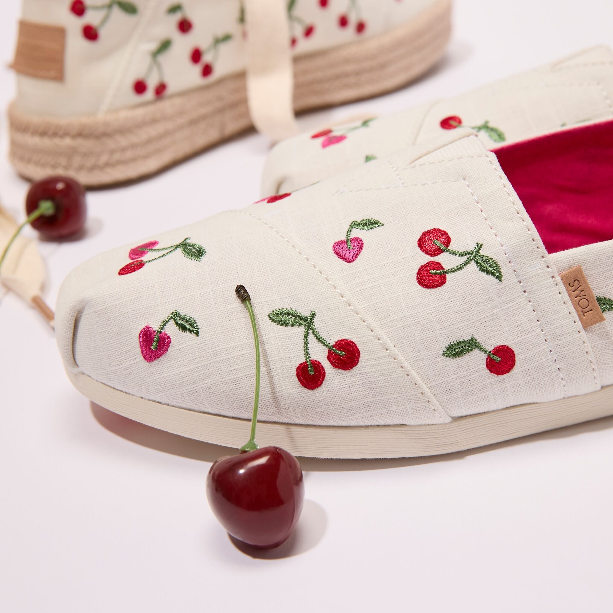 Up close laydown image of the cherry and heart embroidered Alpargata