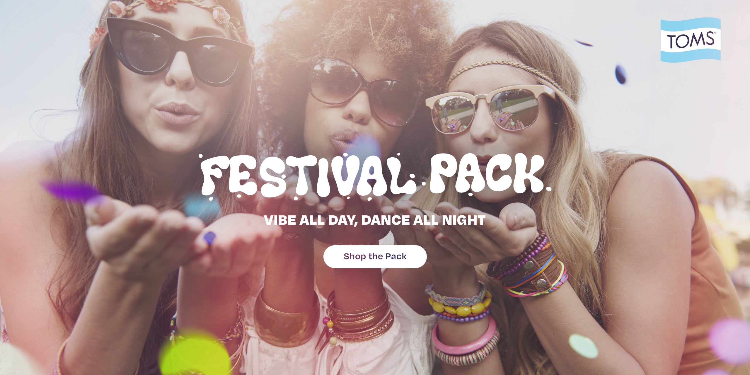 TOMS logo. FESTIVAL PACK. VIBE ALL DAY, DANCE ALL NIGHT. Shop the Pack. Festival scene background with 3 models.