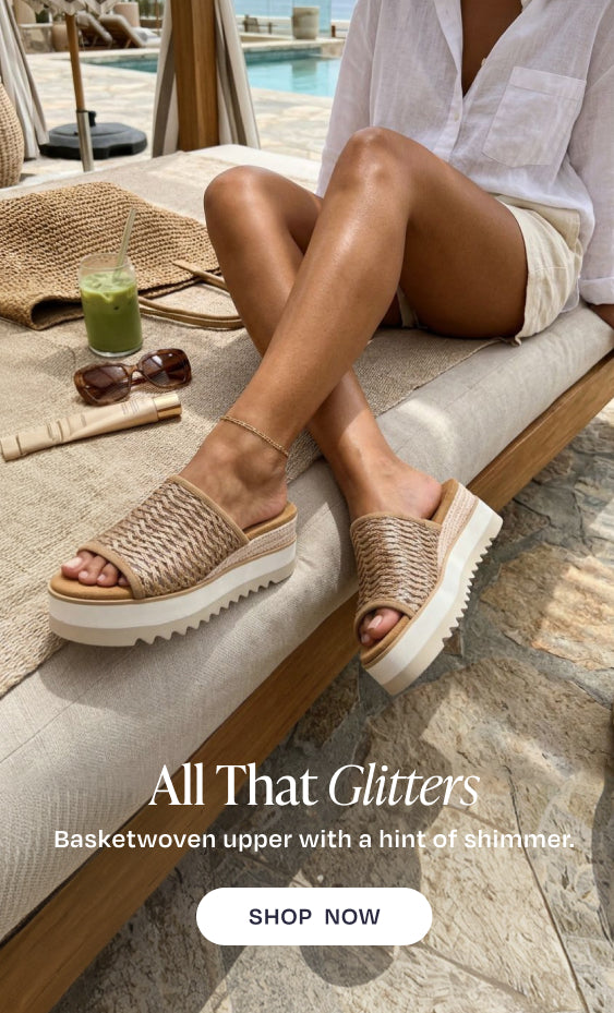All That Glitters. Basketwoven upper with a hint of shimmer. SHOP NOW: Diana Mule Wedge Sandal in Bronze Deco Basket Weave on model. Resort background.