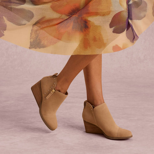 On model image of the Womens Goldie Wedge Ankle Bootie Taupe Suede with Studs
